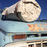 Cowboy Bedroll Cover is made with heavy canvas, two attached harness leather straps. Stationed on the hood of a 1950s Ford Flat Bed Truck