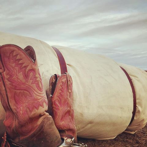 J bar D Canvas Bedroll with cowboy boots in the foreground.